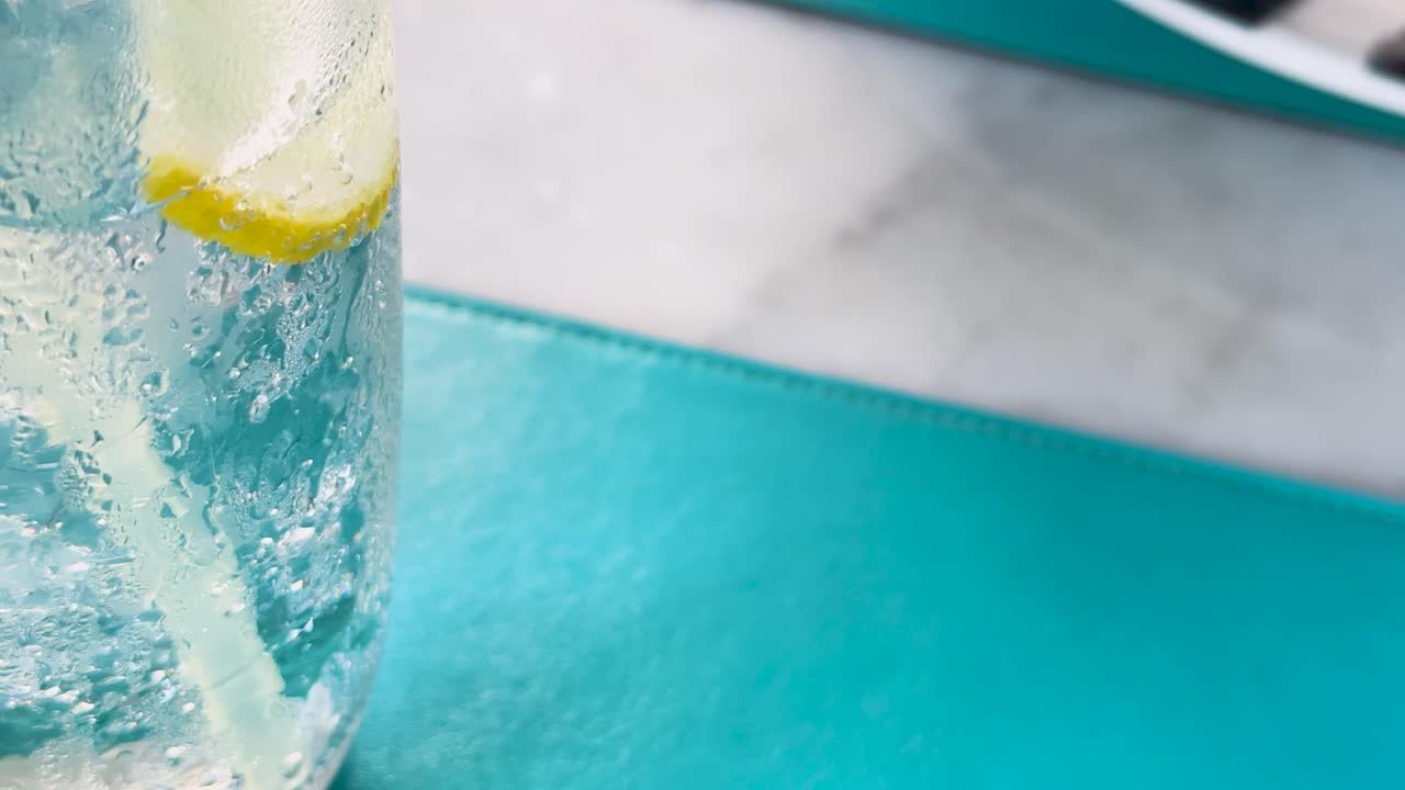 un primer plano de refresco de club con limón y hielo, mostrando burbujas en un entorno brillante y refrescante
