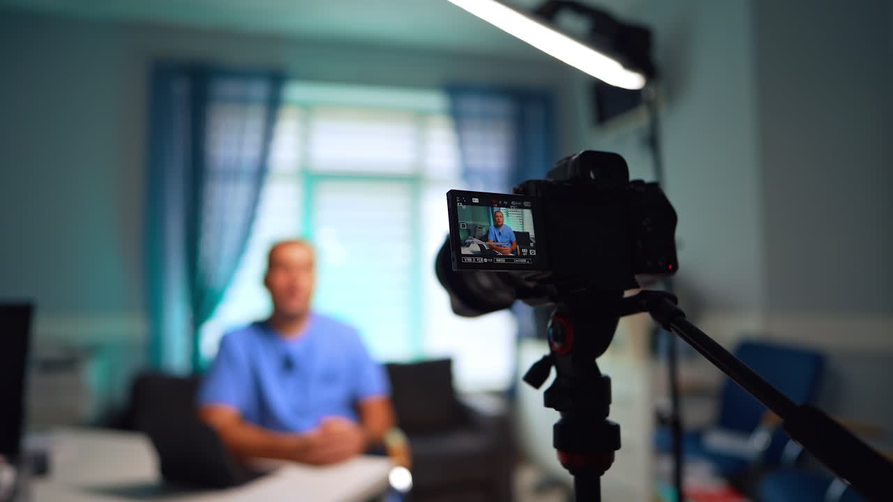 Registrazione di un video con una fotocamera moderna. Un medico parla alla fotocamera per i contenuti del blog. Messa a fuoco selettiva