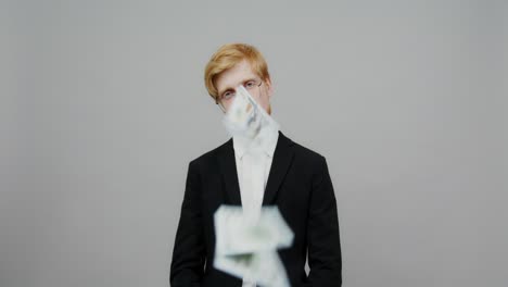 man in suit with money falling around him