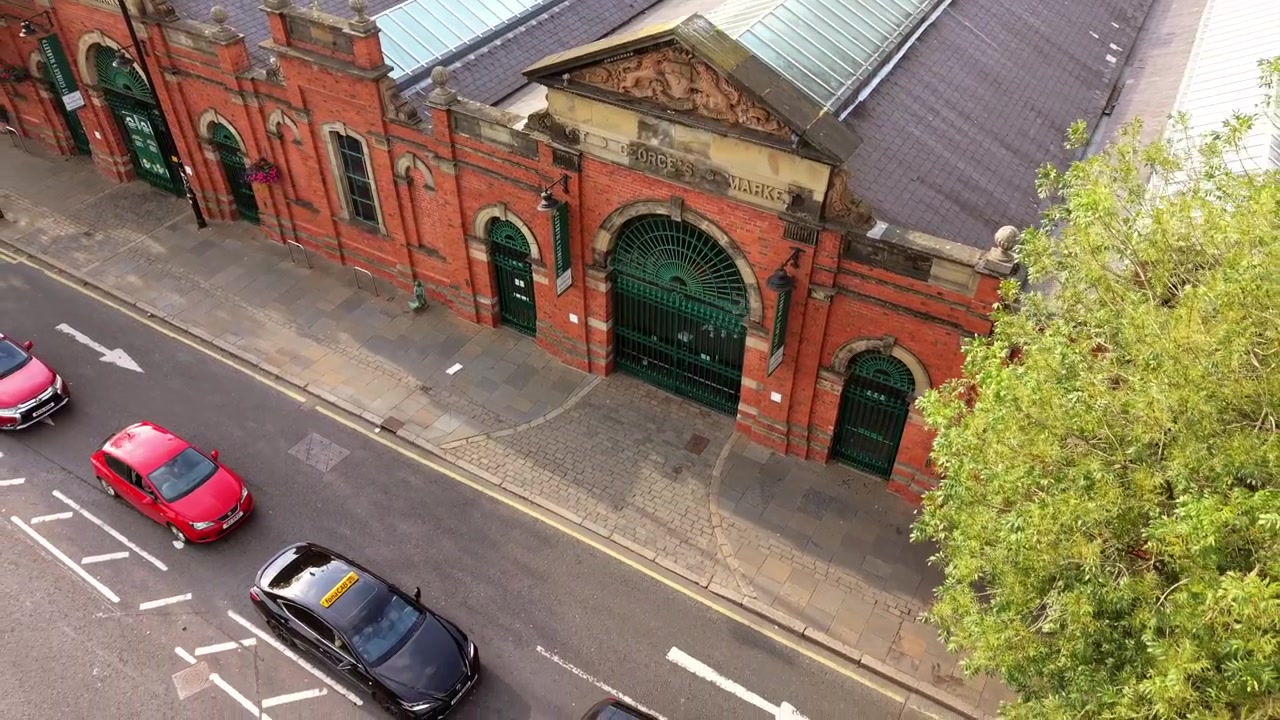 Video aereo invertito 4K 50FPS dall'alto del St George's Market nel centro di Belfast, Irlanda del Nord, Regno Unito. Prodotto con colori Rec709 pronti per la trasmissione.