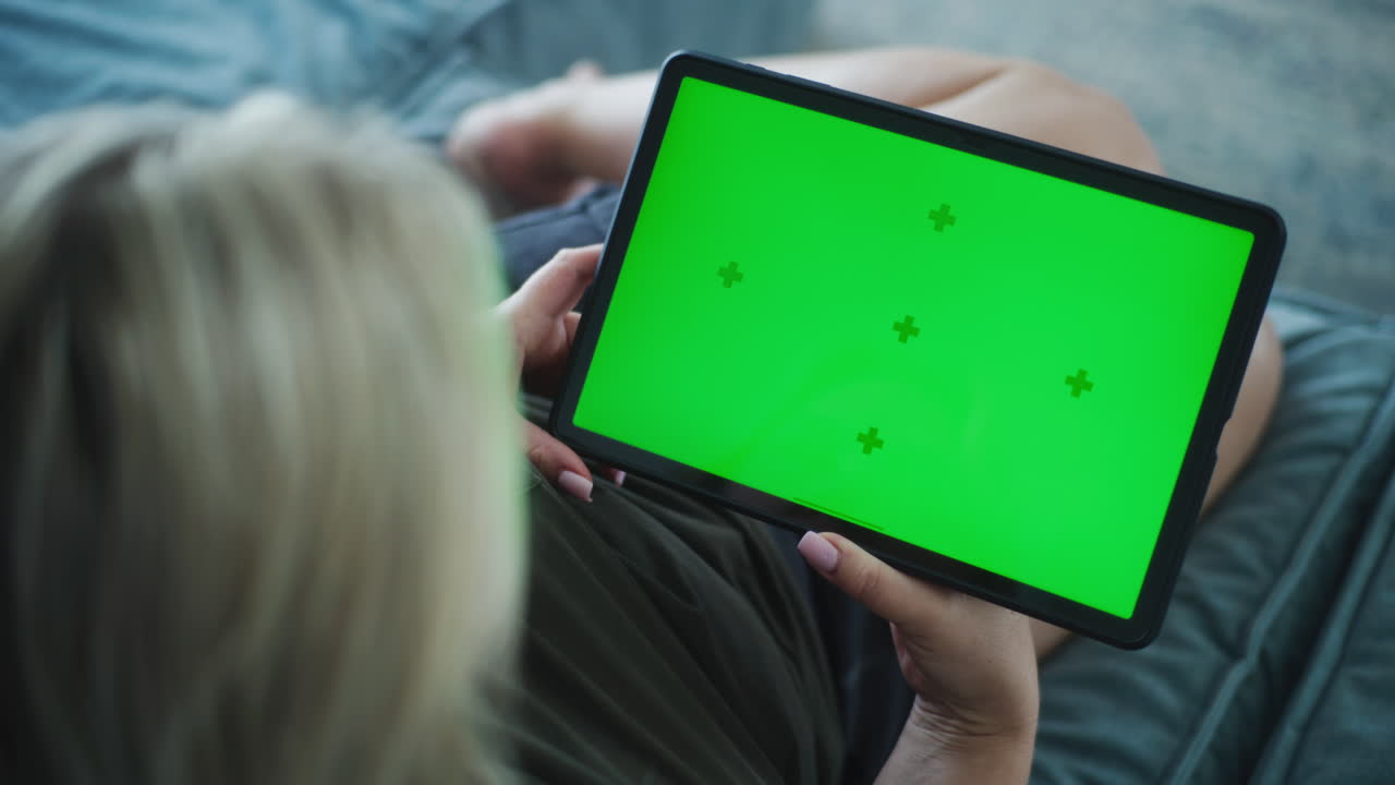 donna che usa un tablet con uno schermo verde