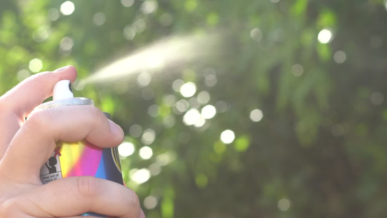 스프레이 페인트 병을 흔들고 테스트하는 손의 총을 닫습니다