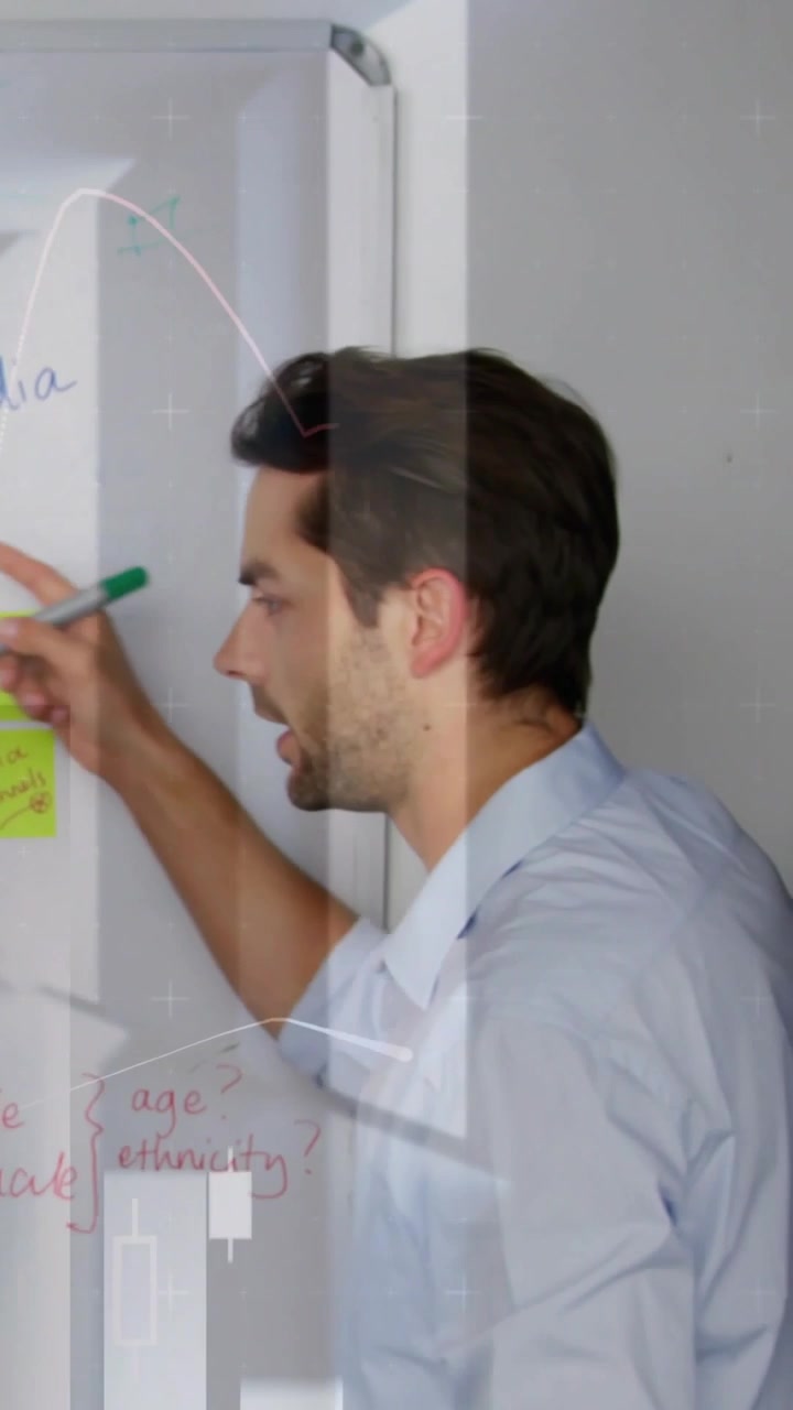Video verticale: Uomo che si protende verso l'alto, scrive con un pennarello, indica appunti, analizzando dati finanziari in sovrimpressione.