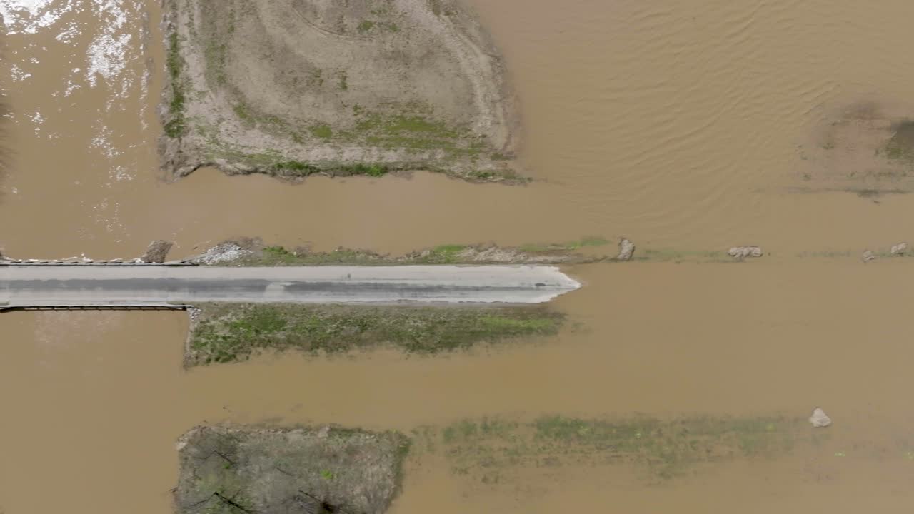 Flooded farm land and rural road in southern Indiana with drone video wide shot above looking down