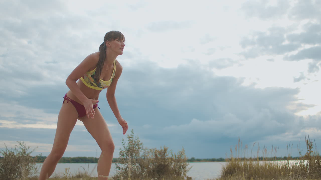 두 명의 여성 팀의 해변 배구 경기 젊은 운동 여성들이 점프하고 공을 공격하고 있습니다.