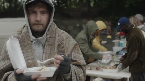 homeless man receives meal at outdoor food distribution event