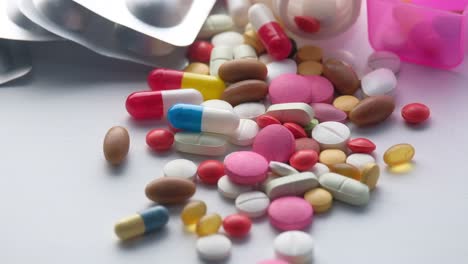 assorted pills and capsules in packaging and container