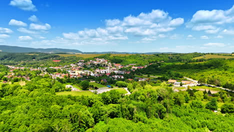 idyllic scenery of rural area on a beautiful sunny day. drone footage approaching picturesque village surrounded by lush greenery. slovakia countryside.