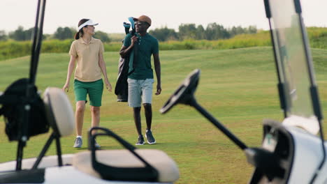 una mujer caucásica y un hombre afroamericano en el campo de golf.