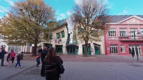 tourists standing in front of a crooked house in sopot