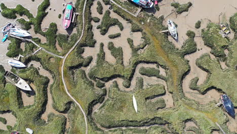 top down slowly descending aerial footage towards a salt marsh estuary at low tide