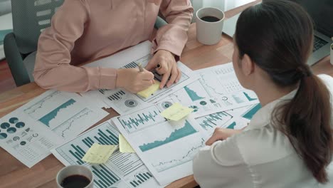 primer plano dos jóvenes mujeres de negocios entusiastas trabajando en la oficina con papel de informe.