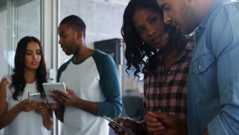 colegas que usan tabletas digitales y teléfonos móviles