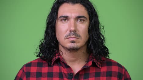 handsome hipster man against green background