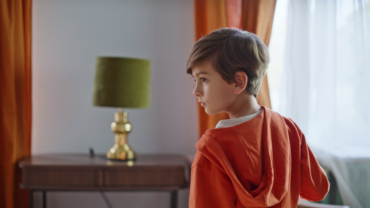 Piccolo aiutante che pulisce il divano di casa con l'aspirapolvere, in primo piano. Ragazzo che usa l'aspirapolvere.