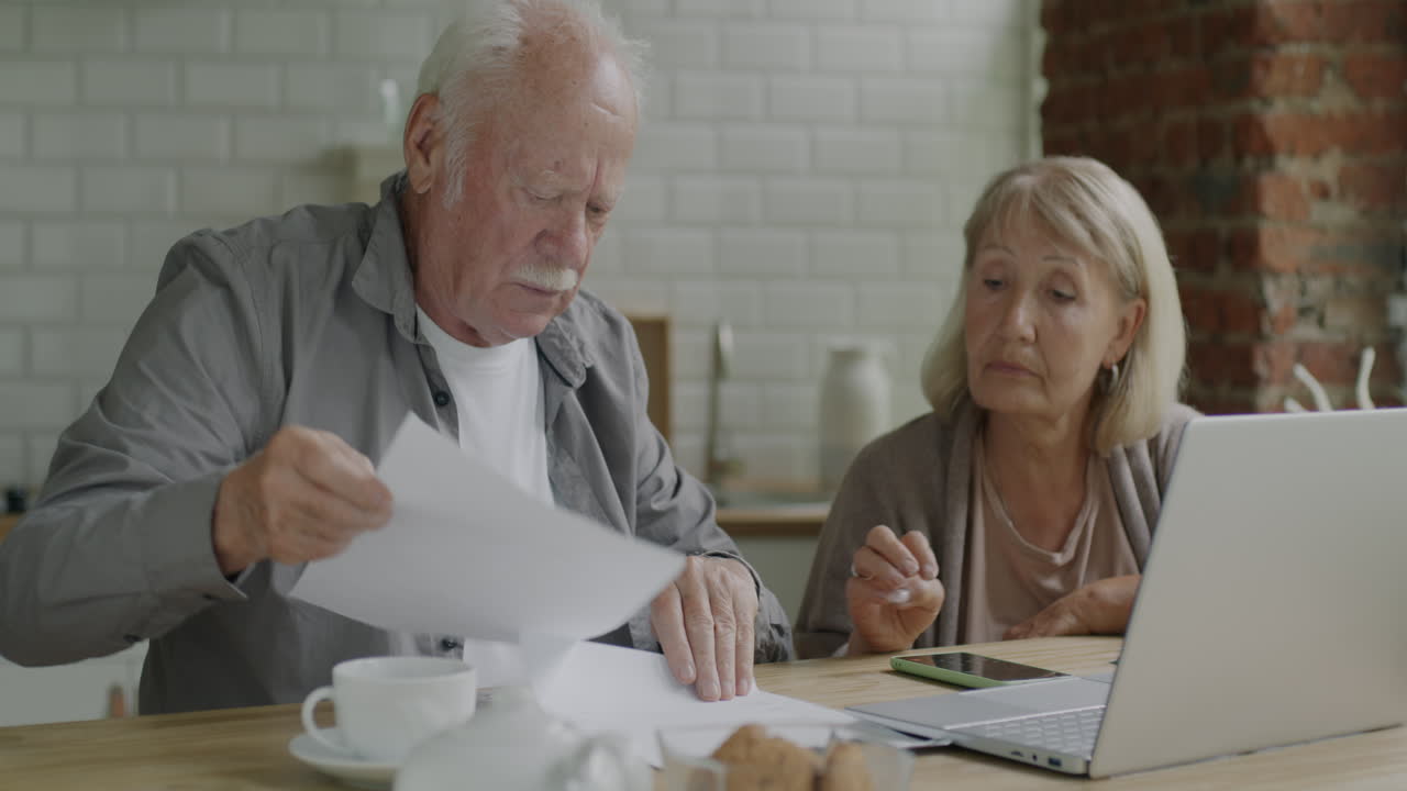 pareja de ancianos revisando documentos financieros