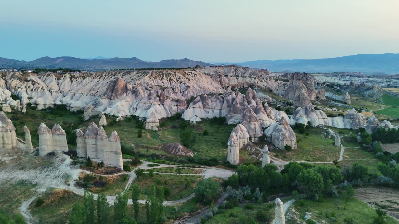 Aerial view of Cappadocia's unique rock formations at dusk, serene landscape