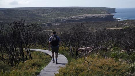 Aufnahme-Von-Zwei-Menschen,-Die-An-Einem-Sonnigen-Tag-Auf-Einem-Pfad-Nahe-Der-Küste-Im-Royal-National-Park-In-Australien-Spazieren