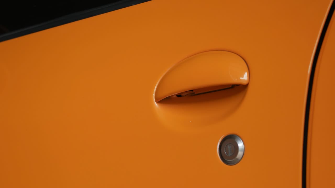 primo piano dell'apertura dello sportello giallo dell'auto