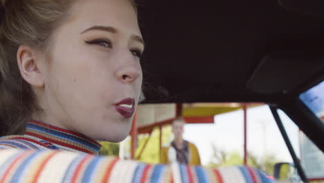 a young woman sits in the car with the window open on a sunny day