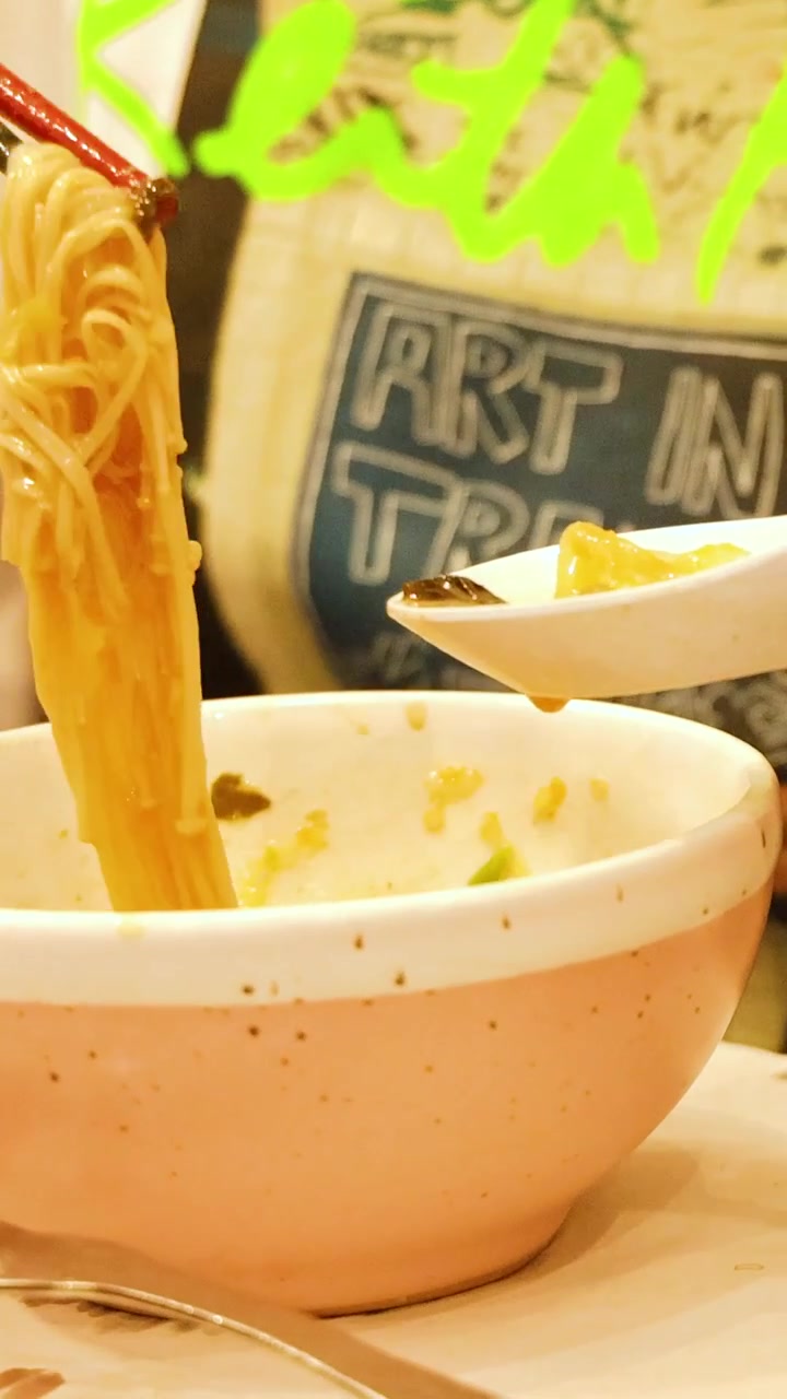 箸とスプーンで鍋料理のスープを味わう人