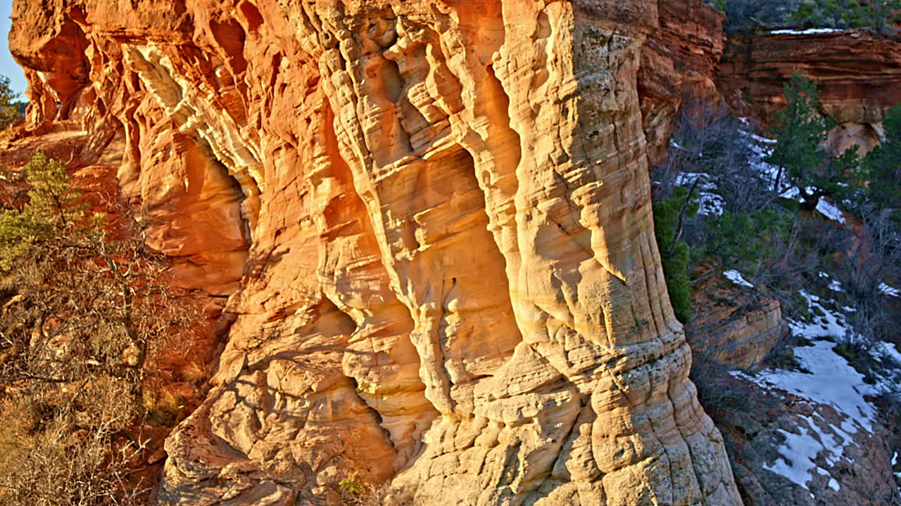 Aerial drone footage capturing a stunning natural arch in a red rock landscape at sunrise near Kanab, Utah.