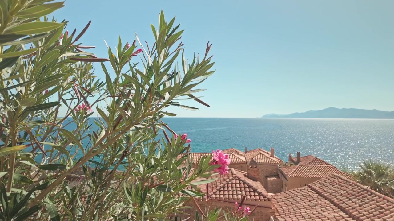 Le soleil scintille sur l'île de la mer Méditerranée, au-dessus des toits rouges de la ville de Monemvasia.