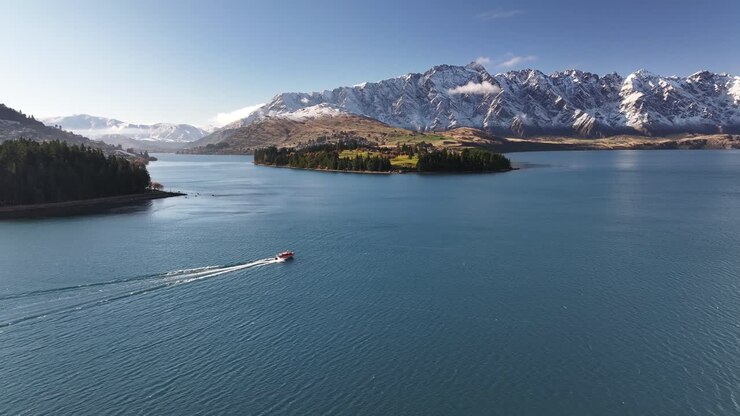 Una piccola barca naviga sul Lago Wakatipu a Queenstown