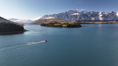 un petit bateau navigue sur le lac wakatipu à queenstown.