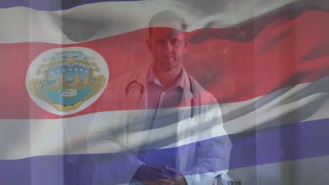Animation-of-waving-flag-of-costa-rica,-caucasian-male-doctor-with-stethoscope-standing-in-hospital