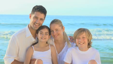 family posing for a photo on a beach
