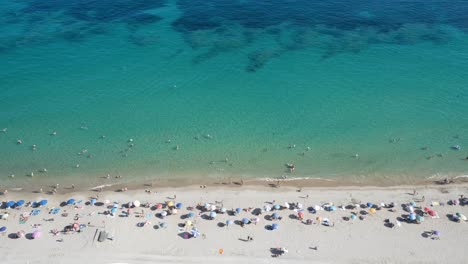 bird’s eye view of busy summer mediterranean beach with visible reef 4k