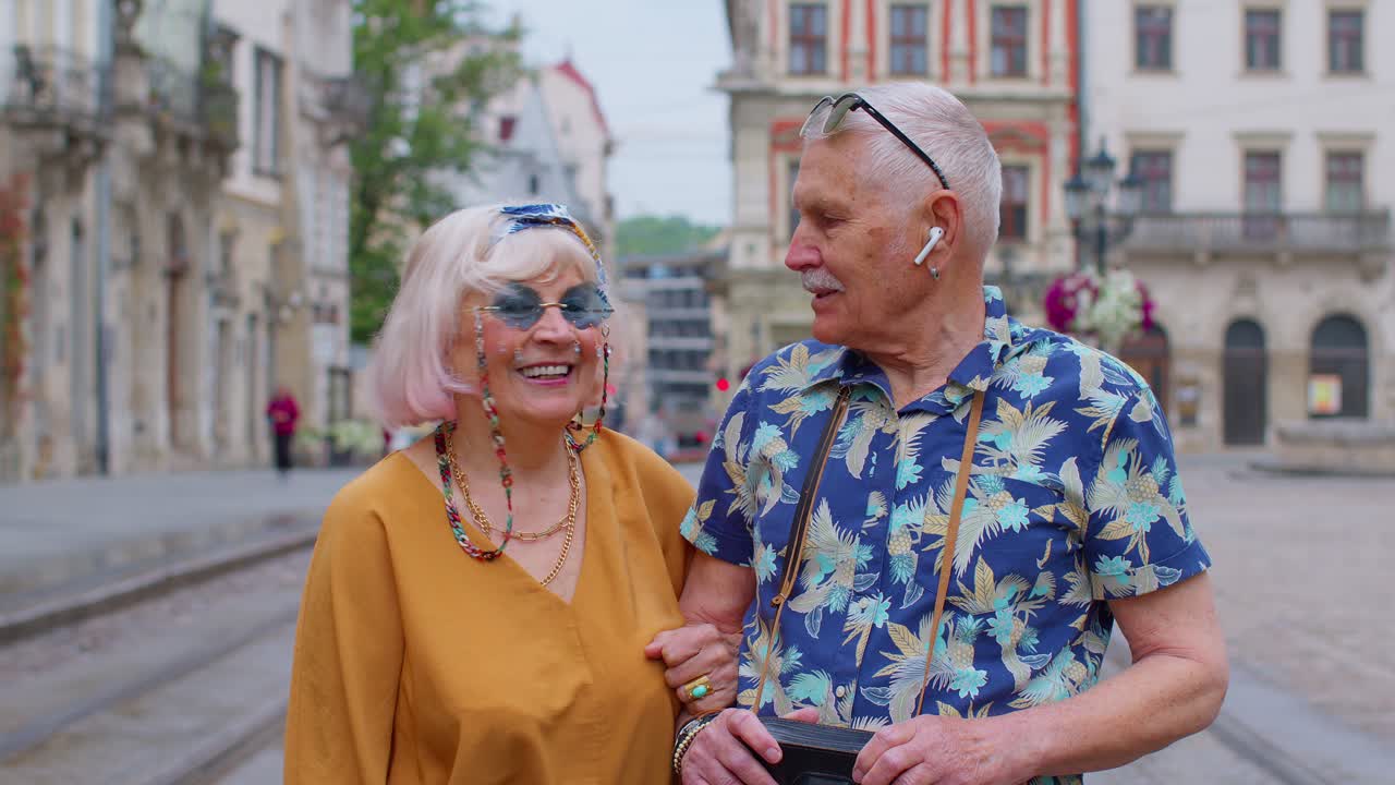 Coppia di anziani turisti eleganti, uomo e donna, che si godono una conversazione per strada nella città di Leopoli, Ucraina.