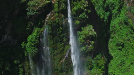 drone shot of huge waterfall and rainbow over lush greenery in nepal stunning view shows a massive cliff, offering exploration fun and adventurous travel to nepal’s authentic natural areas