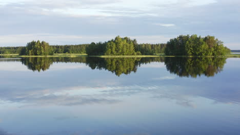 tranquil lake scenery by sunset with three islands in the background