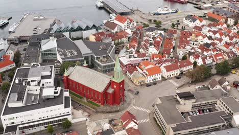 Aerial-View-of-St-Petri-Catholic-Church-and-Traditional-Houses-in-Stavanger-City-Norway,-Orbit-Drone-Shot-Revealing-Downtown-and-Harbor