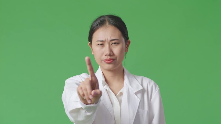 Asian woman in lab coat pointing