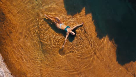 girl in a natural rock pool next to the sea in kefalonia island, greece