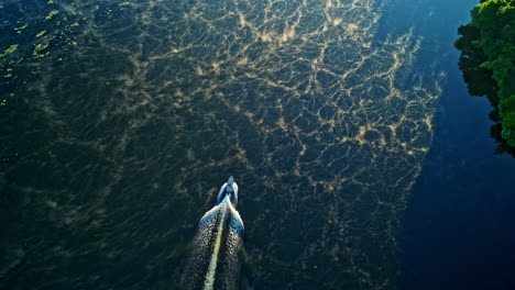 slow motion drone footage for motorboat cruising up a foggy river at sunrsie