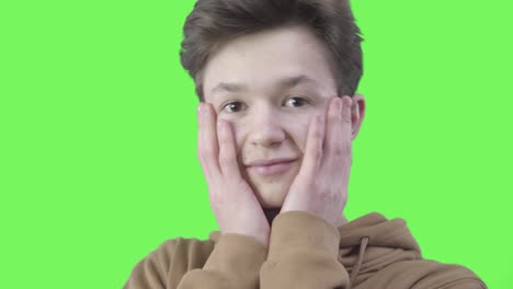 close-up of shocked guy holding face with hands and shaking head. portrait of brunette caucasian teenage boy showing surprised emotion. feelings, reaction, lifestyle.