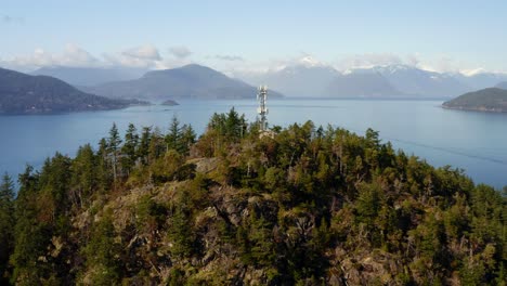 cell tower on forested hill in horseshoe bay overlooking howe sound in west vancouver, bc, canada