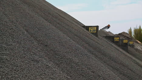 large pile of gravel. building materials in the concrete plant outdoors. gravel production. crushed stones on a big heap against the clear sky.