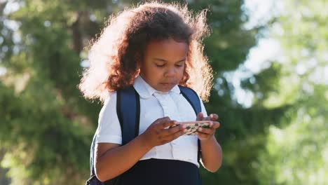 girl in uniform using smartphone outdoors