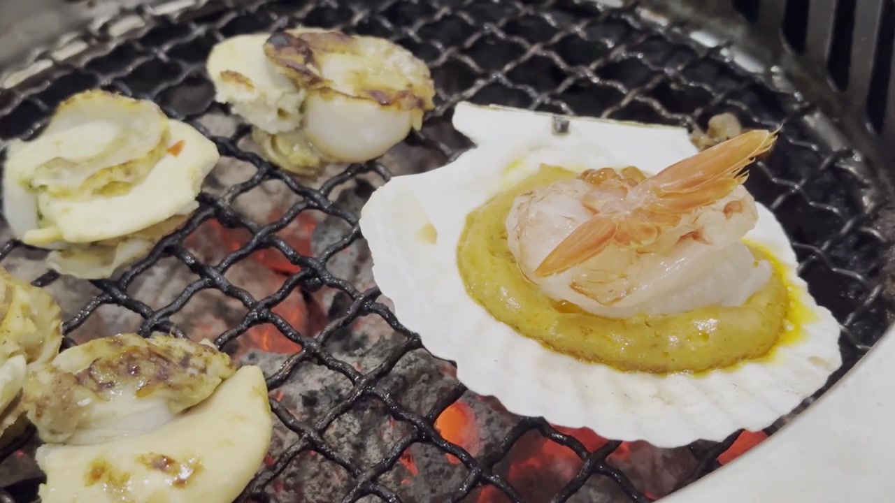 Close-up of fresh scallops grilling on a hot barbecue surface, capturing sizzling texture, rising steam, and delicious seafood cooking.