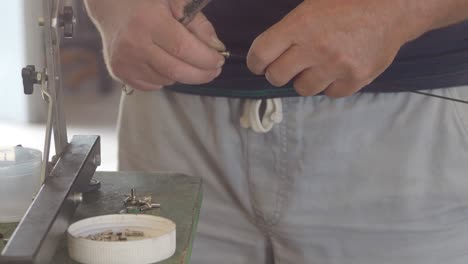 close up of a technician's hands meticulously cleaning a bicycle rim component using a wire brush, ensuring its proper function and maintenance