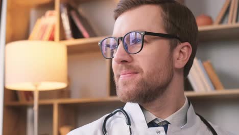 handsome and young doctor staring at camera in office