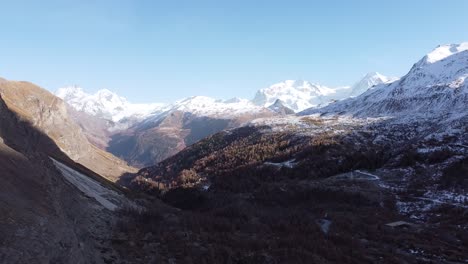 vista de drones de un valle suizo con los alpes nevados en el fondo, soleado