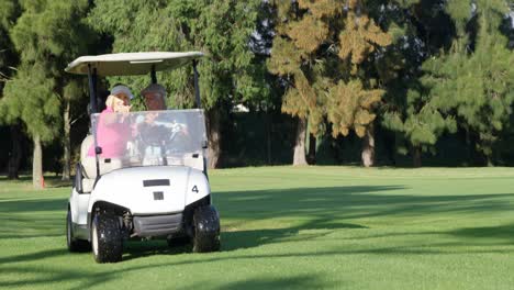 two golfers driving in their golf buggy