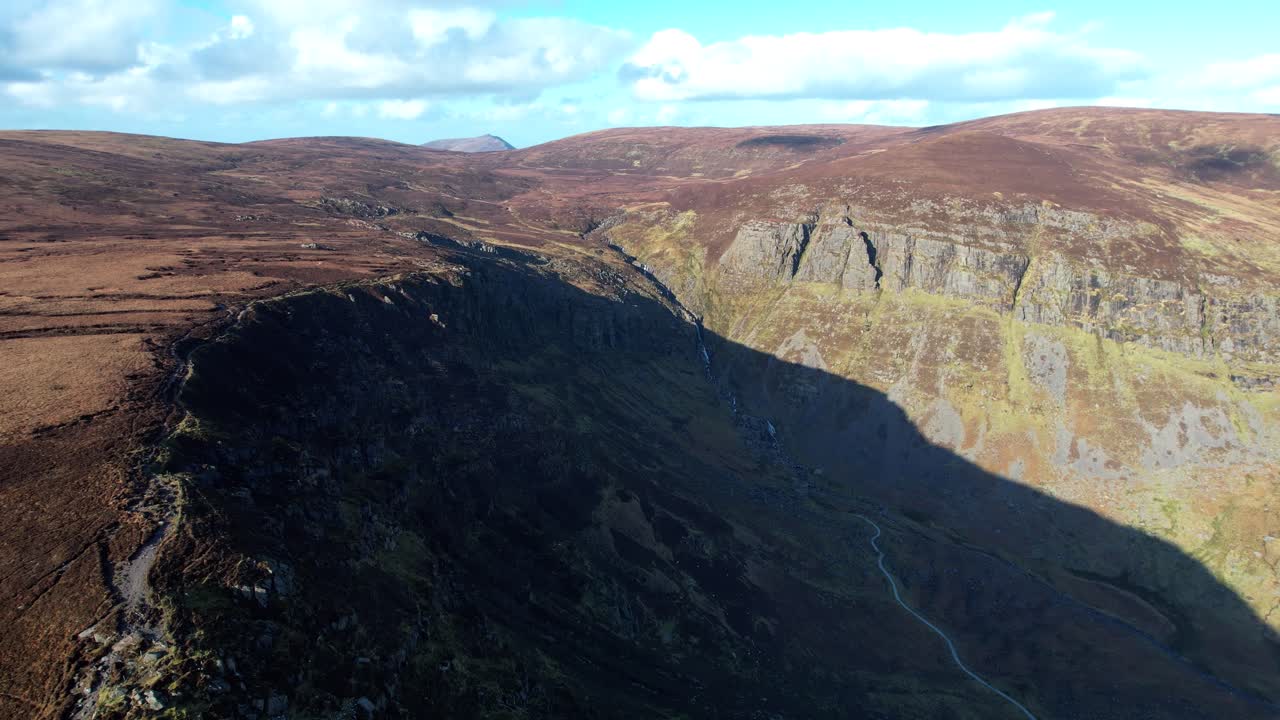 Irish Mountains drone flying up the Mahon Valley in winter shadows and the expanse of the Comeragh plateau in winter sun Waterford wild places