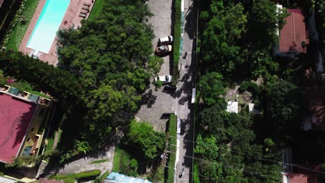 Overhead-drone-shot-of-mountain-bikers-riding-through-a-small-town-by-a-lake